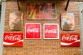 Classic trademark branding logo of CoCa-Cola collection on red brick wall.